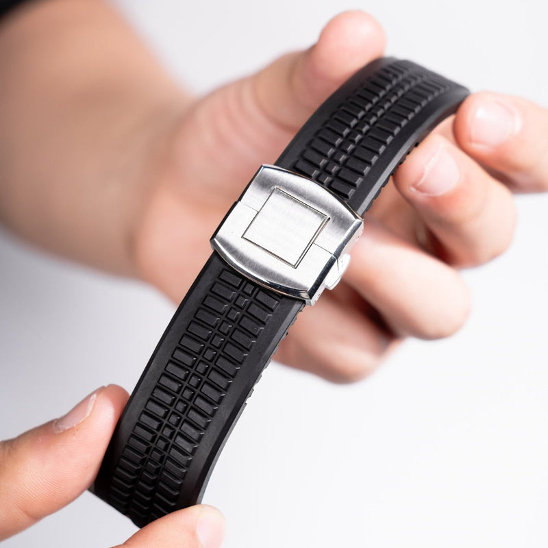 Bracelet Apple Watch en silicone noir texturé avec boucle ajustable double en métal argenté.