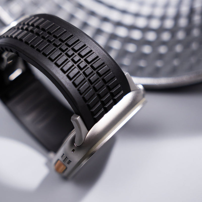 Bracelet Apple Watch en silicone noir texturé, boucle ajustable double, style sport robuste.