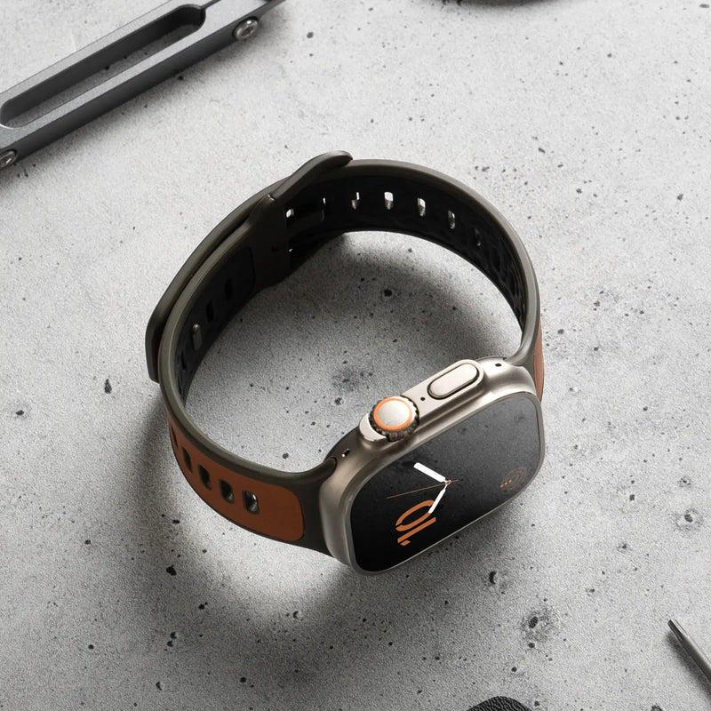Bracelet Apple Watch hybride cuir marron et fluoroélastomère noir avec boucle ajustable.