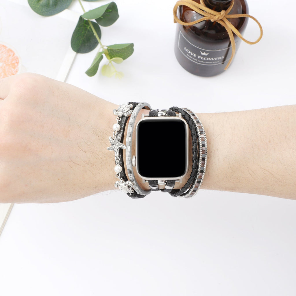 Bracelet pour Apple Watch en simili vegan noir avec perles blanches, tortue et étoile de mer argentées, style tropical chic.