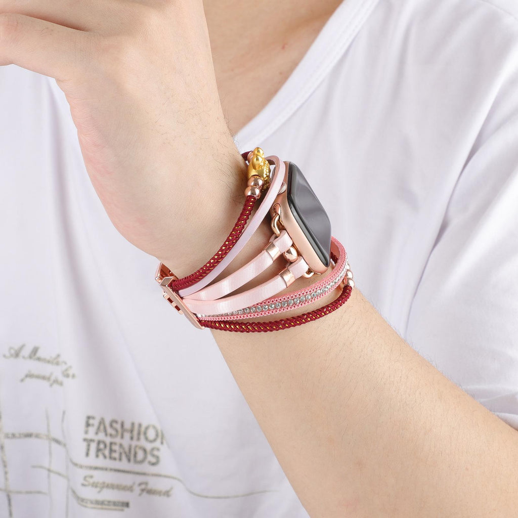 Bracelet Apple Watch doré avec perles et strass rouges, breloque ours en métal brillant, style raffiné et féminin.