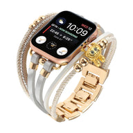 Bracelet doré pour Apple Watch avec double lanière perlée, strass brillants et breloque ours teddy élégante.