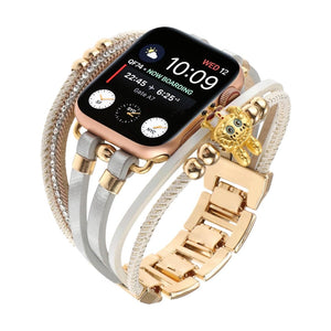 Bracelet doré pour Apple Watch avec double lanière perlée, strass brillants et breloque ours teddy élégante.