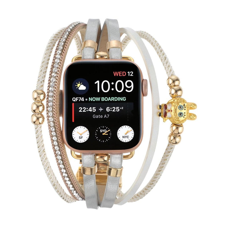 Bracelet doré pour Apple Watch avec multiple rangs en perles dorées, strass brillants et breloque ours teddy élégante.