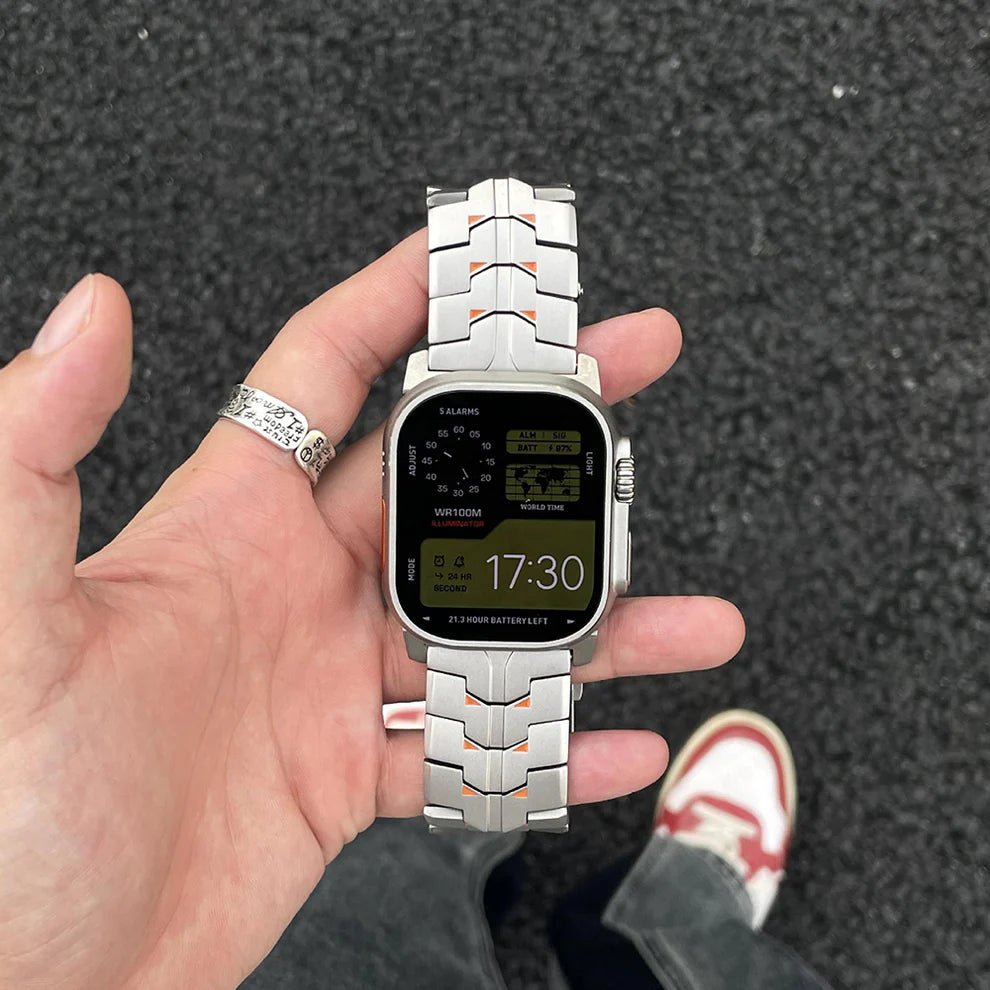Bracelet connecté titane massif argenté, maillons larges et fermeture à boucle, style techwear pour Apple Watch Ultra.