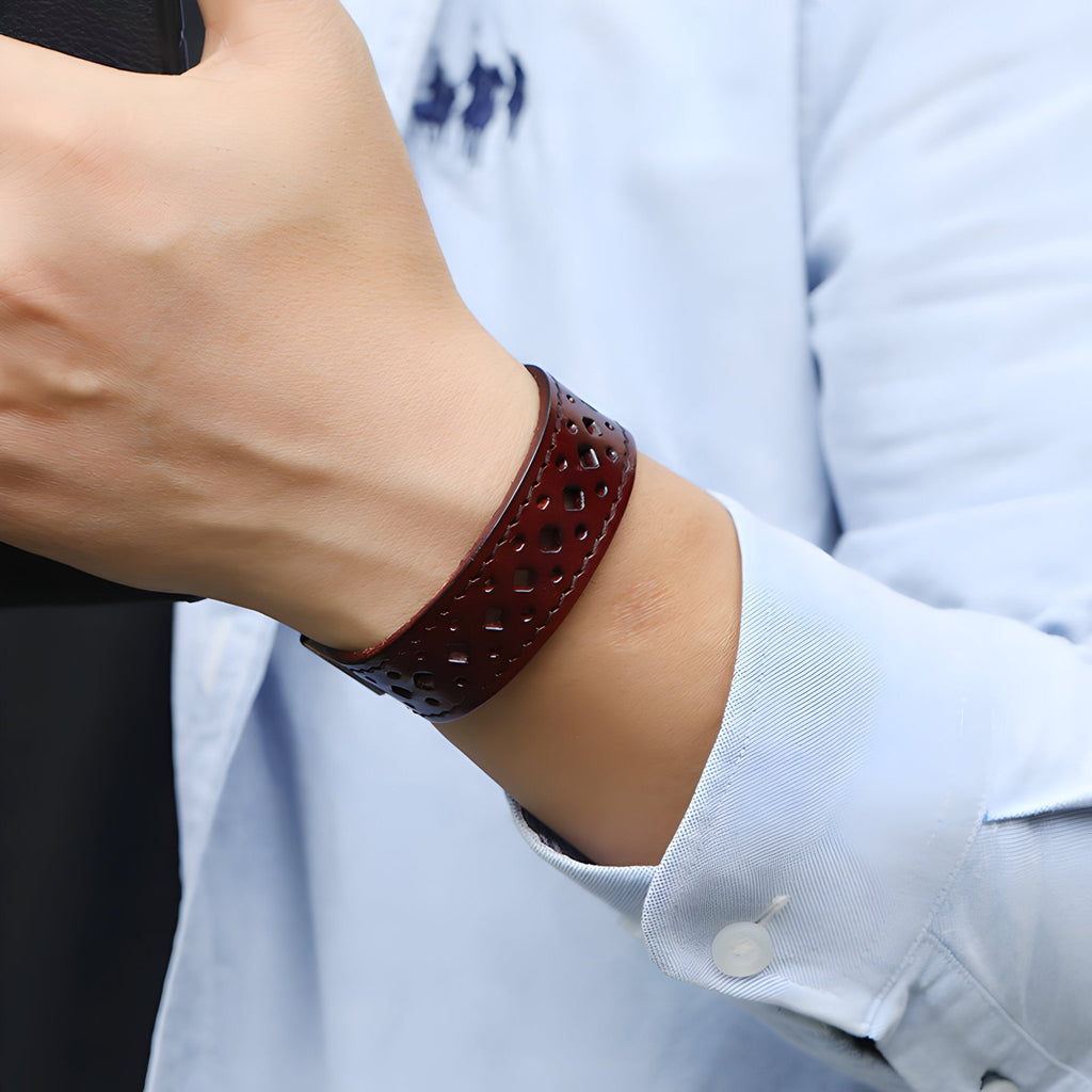 Bracelet ardillon en cuir café à perforations fines, style rétro, porté au poignet homme.