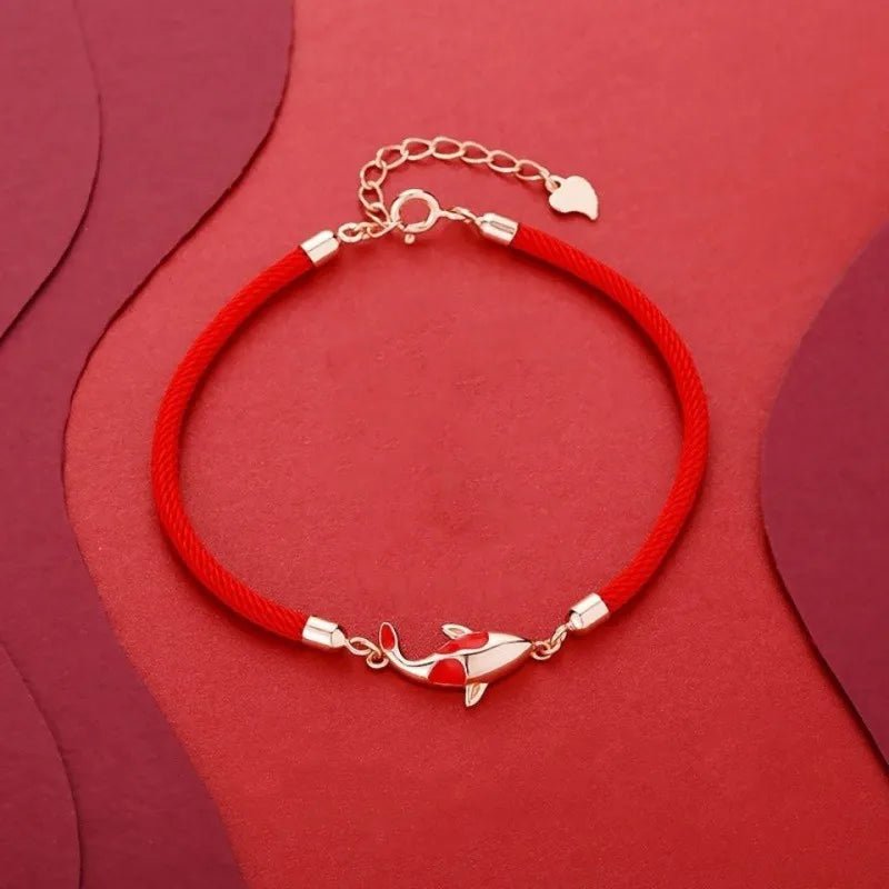 Bracelet rouge en fil ciré avec symbole carpe koï en métal doré, fermoir chaîne ajustable.