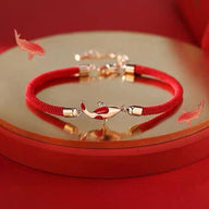 Bracelet en fil rouge ciré avec pendentif carpe koï argenté et détails rouges, style élégant et fin.