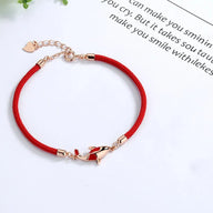 Bracelet fin en fil rouge ciré avec breloque carpe koï en métal doré et détails rouges.