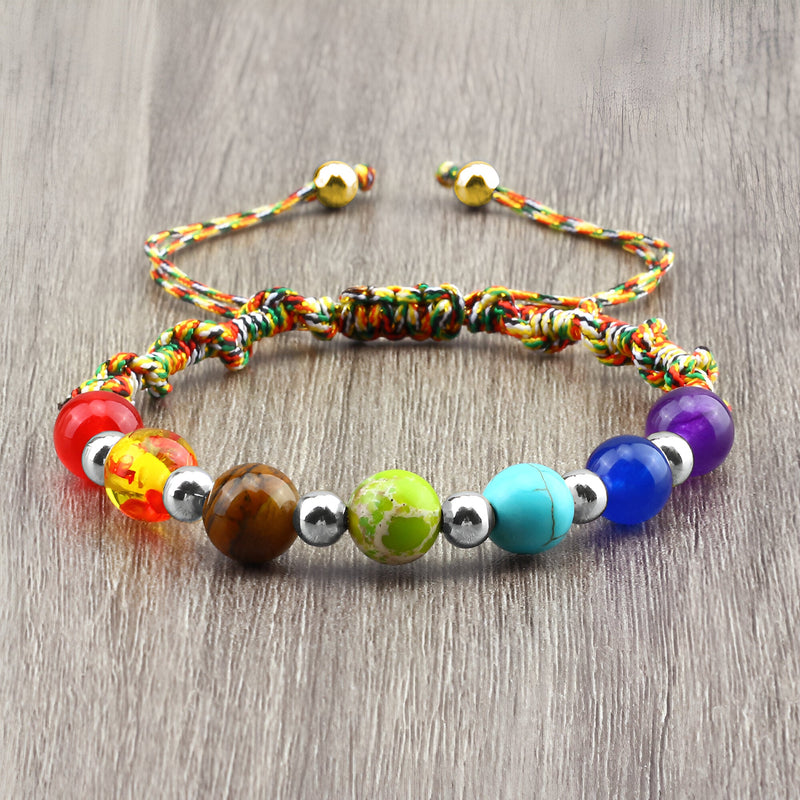 Bracelet aux 7 chakras en corde multicolore avec perles en pierres naturelles de couleurs variées et fermoir coulissant doré.
