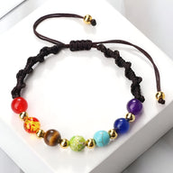 Bracelet ajustable noir en corde avec sept perles colorées représentant les chakras, finition dorée.