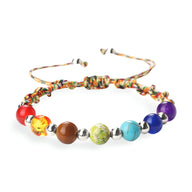 Bracelet aux 7 chakras avec perles colorées en pierres naturelles sur corde multicolore tressée ajustable.