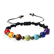 Bracelet aux 7 chakras avec pierres naturelles multicolores sur corde noire ajustable.