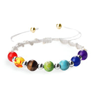 Bracelet aux 7 chakras en corde blanche avec perles colorées semi-précieuses et fermoirs dorés ajustables.