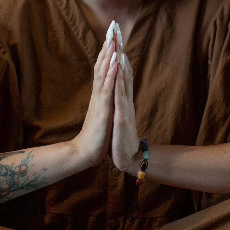 Bracelet Solva en corde avec pierres naturelles multicolores porté au poignet.