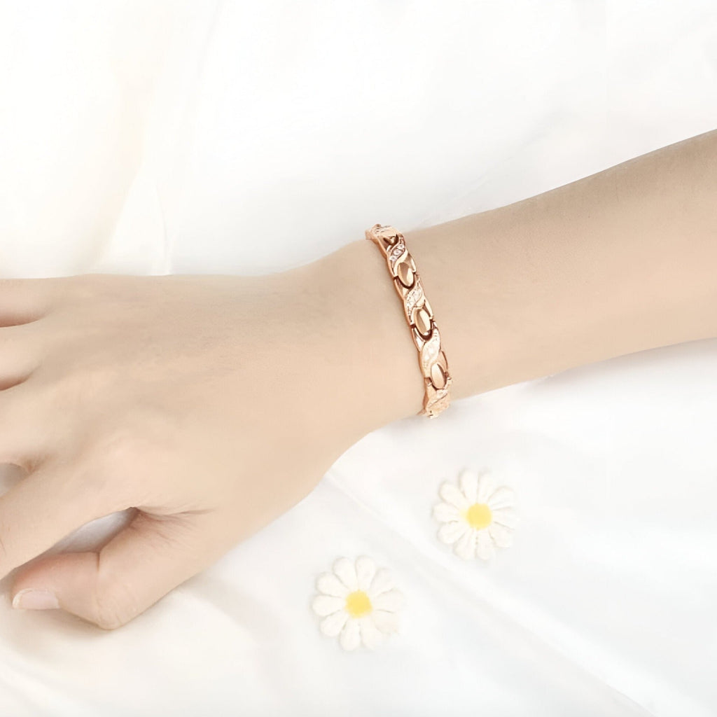 Bracelet femme en titane or rosé avec maillons incurvés et hématites intégrées.