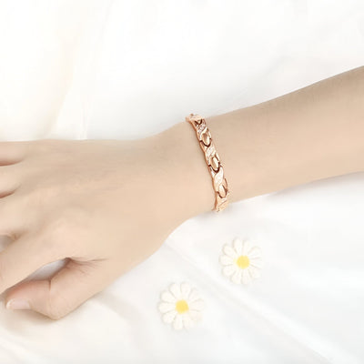 Bracelet femme en titane or rosé avec maillons incurvés et hématites intégrées.