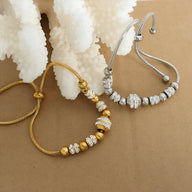 Bracelet ajustable avec perles en titane plaqué or et argent, ornées de cristaux étincelants.