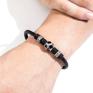 Bracelet masculin en cuir noir tressé avec ballon de foot en acier inoxydable au centre.