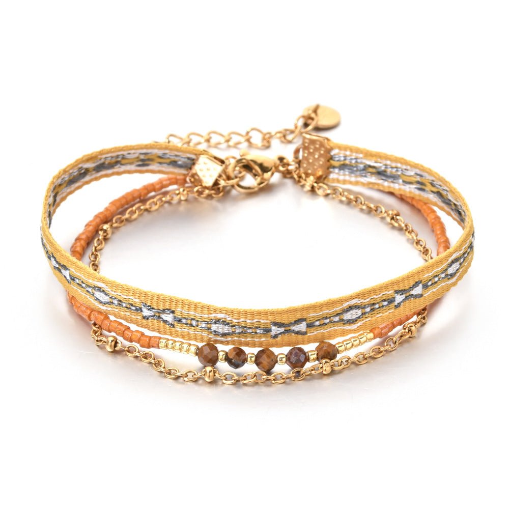 Bracelet bohème multirangs avec perles marron, ruban rayé jaune et gris, chaîne dorée fine, fermoir mousqueton.