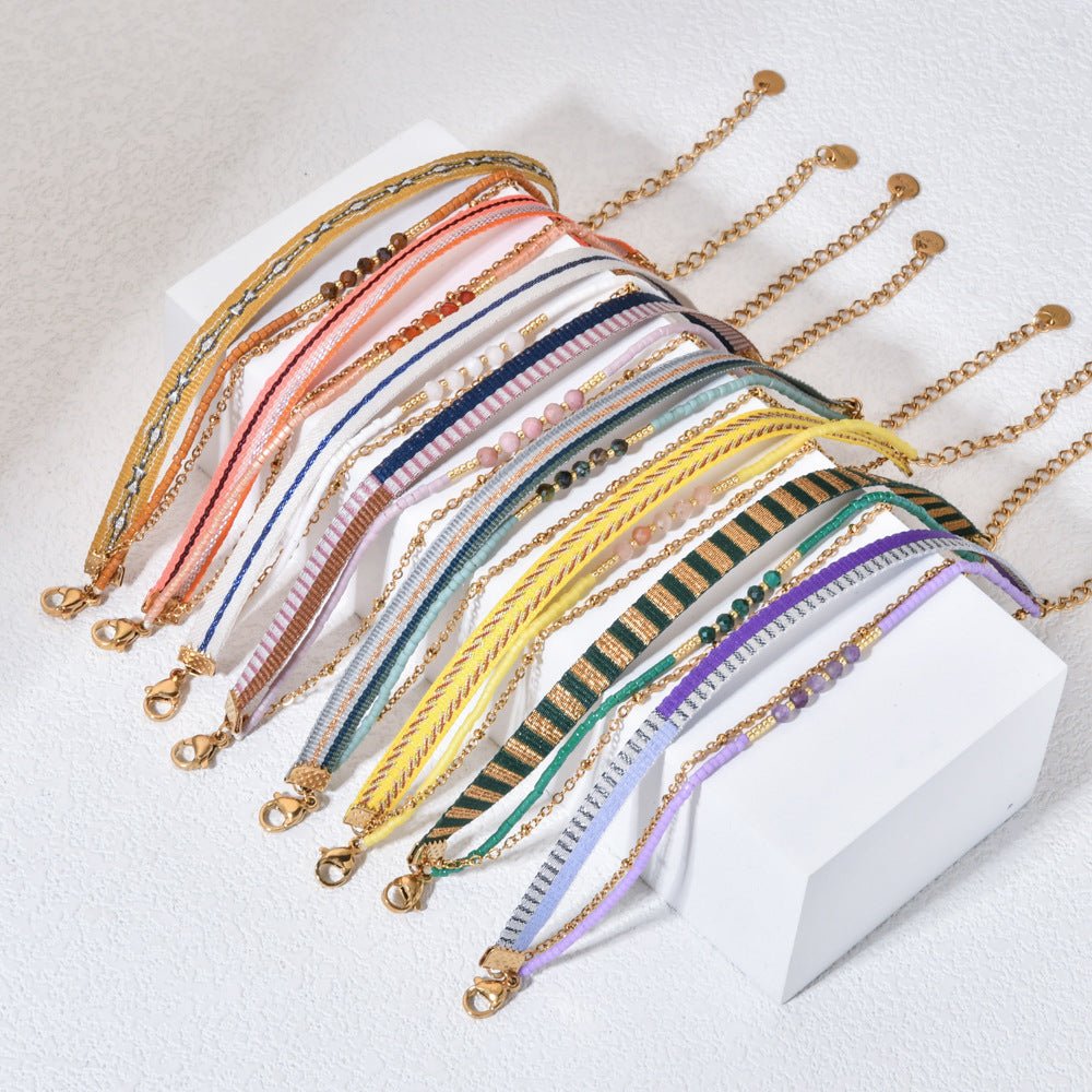 Bracelet bohème multirangs avec perles colorées, rubans rayés variés et chaîne dorée délicate, fermoir mousqueton.