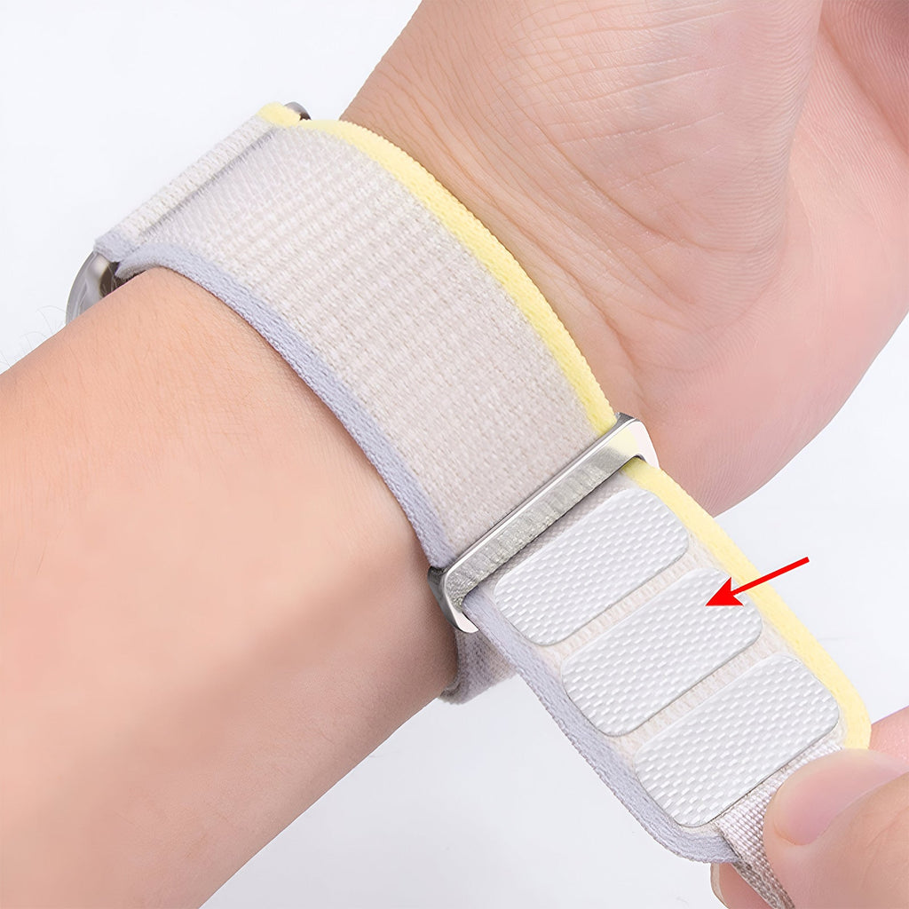 Bracelet Apple Watch Trail Edition en nylon gris clair avec doublure jaune et fermeture velcro ajustable.