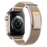 Bracelet Apple Watch en nylon beige tissé avec fil rose et jaune, fermeture velcro réglable.
