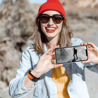 Bracelet Trail Edition en nylon orange avec fermeture velcro pour Apple Watch, porté au poignet femme.