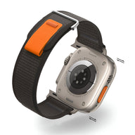 Bracelet Apple Watch en nylon noir avec boucle velcro orange et boucle métallique argentée.