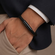 Bracelet câble noir en acier inoxydable avec fermoir tubulaire noir porté au poignet.