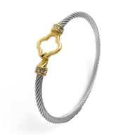 Bracelet câble en acier inoxydable argent avec fermoir doré orné de petits cristaux.