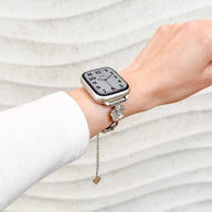 Bracelet chaîne métallique argenté avec pendentifs fleur de cerisier et cœur pour Apple Watch.