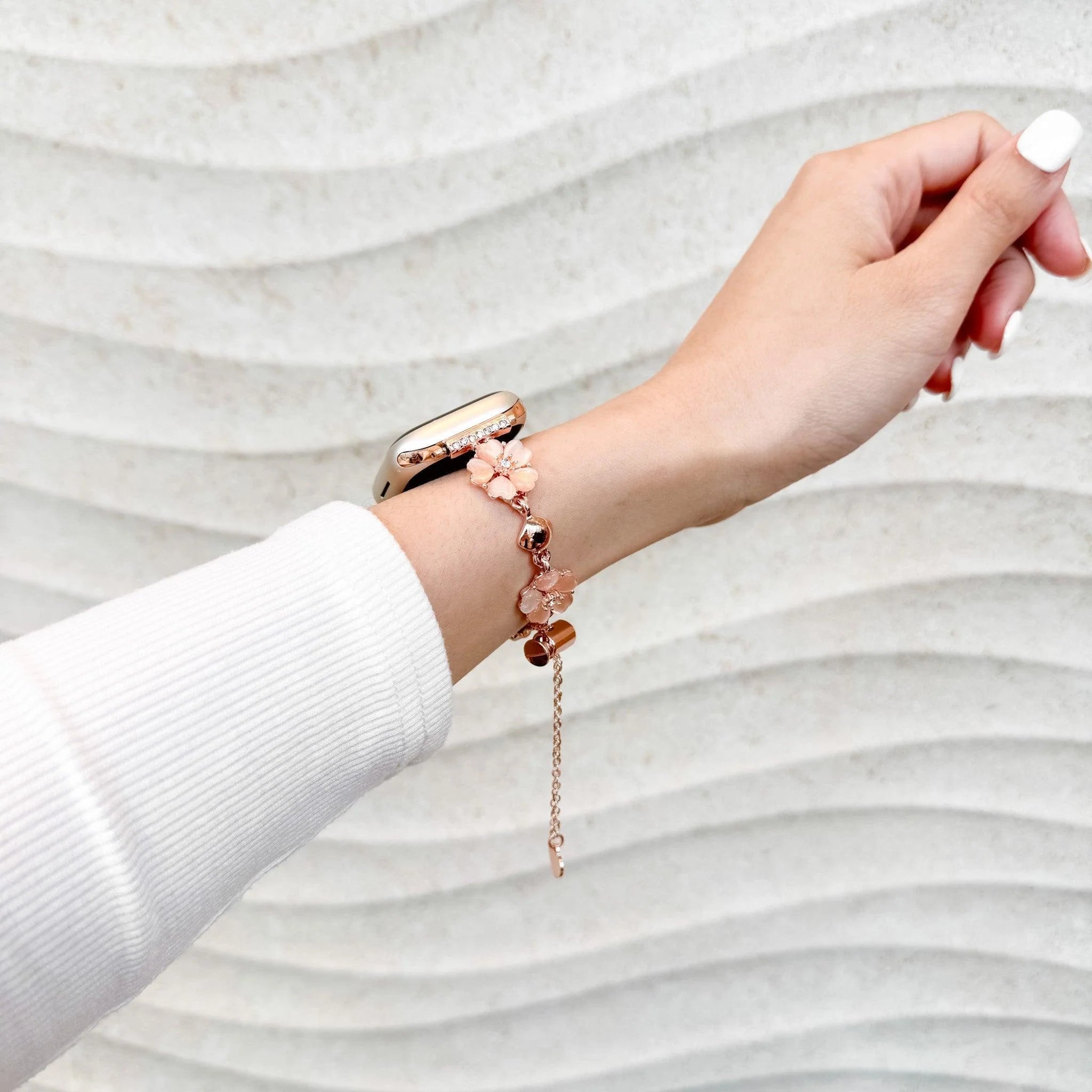 Bracelet chaîne en métal rose doré avec fleurs de cerisier pour Apple Watch, style délicat et féminin.