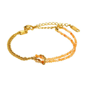 Bracelet doré avec chaîne torsadée et double rangée de perles naturelles orangées, fermoir ajustable.