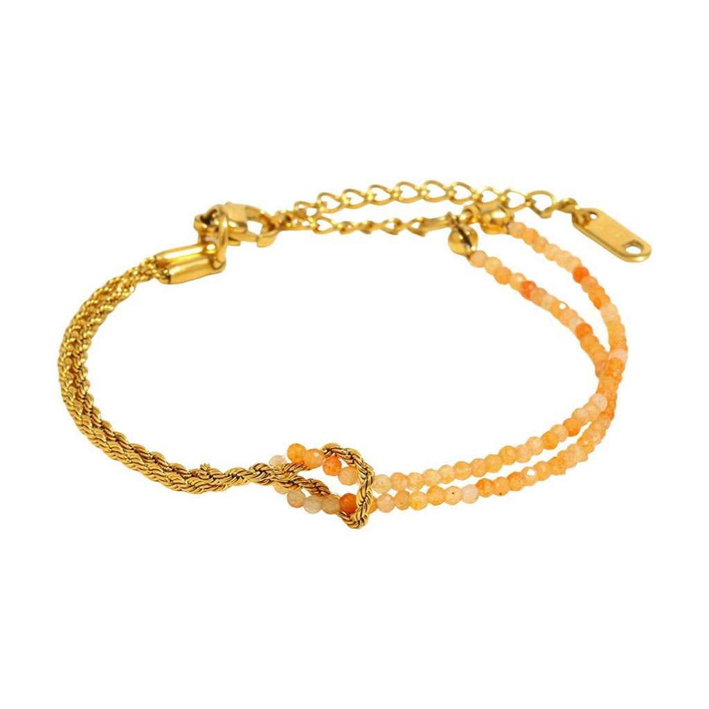 Bracelet doré avec chaîne torsadée et double rangée de perles naturelles orangées, fermoir ajustable.