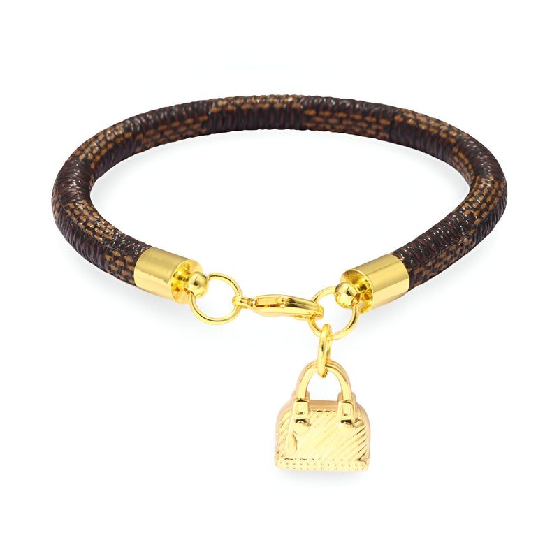 Bracelet charm sac à main en microfibre café avec breloque sac dorée et fermoir mousqueton doré.