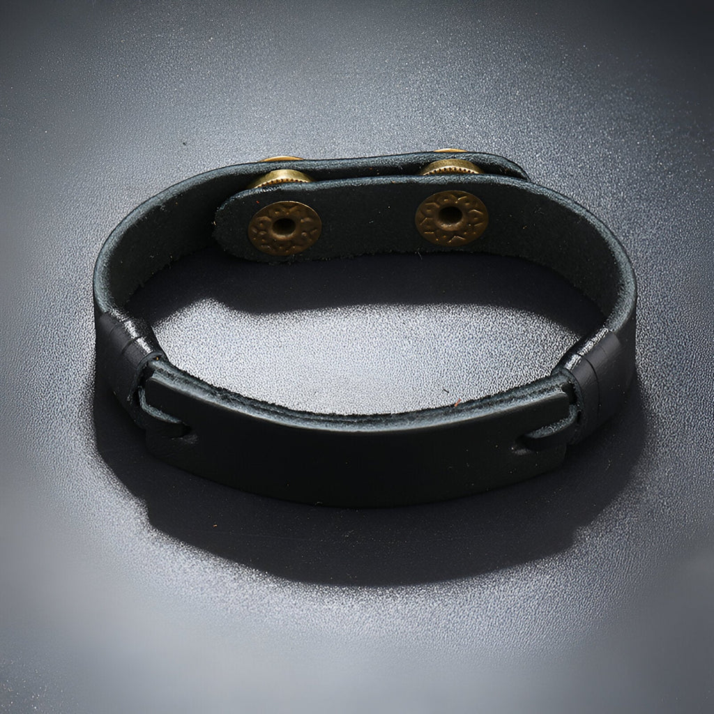 Bracelet homme en cuir noir effet vintage avec double pression métallique dorée.