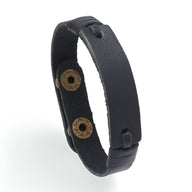 Bracelet en cuir noir mat, style vintage, fermeture à boutons-pression métalliques dorés.