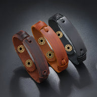 Lot de trois bracelets cuir vintage pour homme en noir, café et marron avec fermoirs métalliques ronds dorés.