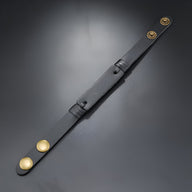 Bracelet en cuir noir effet vintage pour homme avec fermoirs dorés ronds.