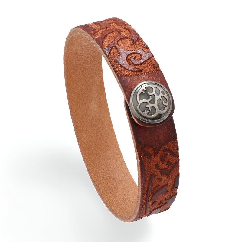 Bracelet en cuir cognac avec motif floral gravé et bouton métallique décoratif argenté.