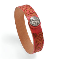 Bracelet en cuir rouge avec motif floral gravé et bouton-pression en métal argenté.