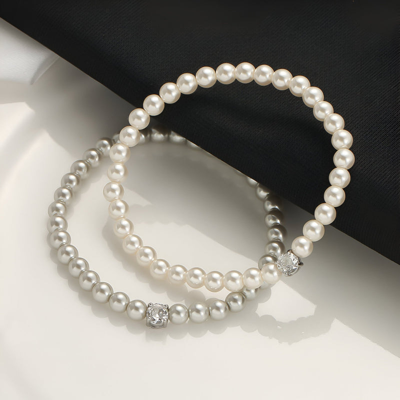 Bracelet chic en perles d'imitation blanches avec un détail strass élégant.