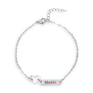 Bracelet en acier inoxydable argenté avec chaîne fine, plaque gravée "Mekhi" et pendentif cœur ajouré.