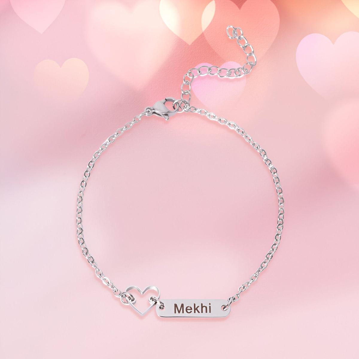 Bracelet fin en acier inoxydable argenté avec pendentif plaque gravée et cœur ajouré.