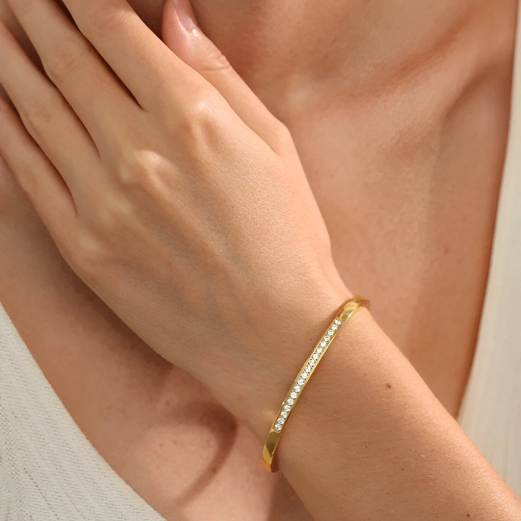 Bracelet fin doré orné de petits cristaux brillants, style élégant et délicat pour femme.