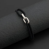 Bracelet cordon noir avec maillons croisés argentés, modèle Everett élégant et unisexe.