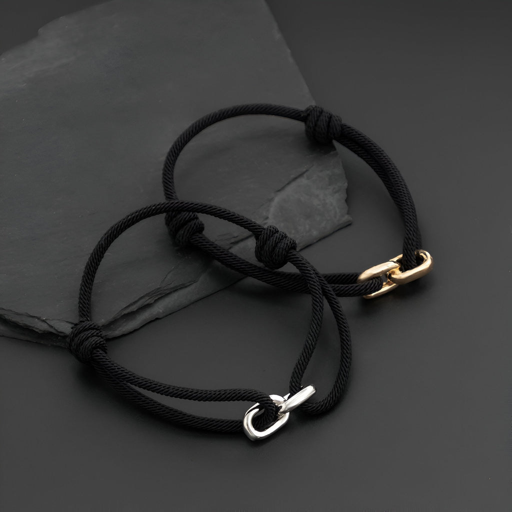Bracelet cordon noir avec maillon croisé en métal argenté, style ajustable.