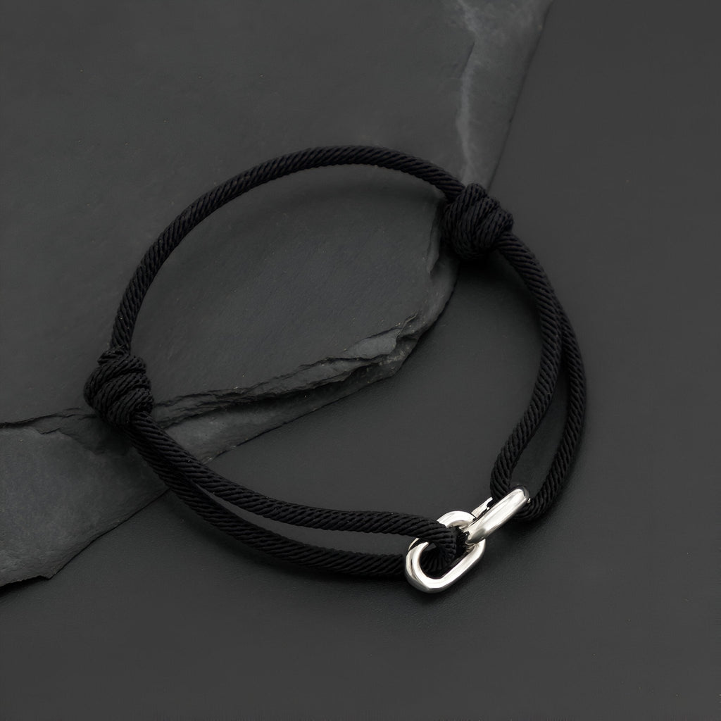 Bracelet cordon noir avec maillon croisé argenté et fermoir à mousqueton.