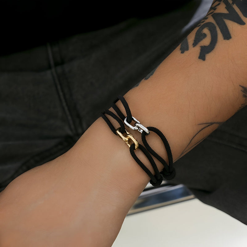 Bracelet cordon noir avec maillons croisés argent et or, style unisexe moderne.